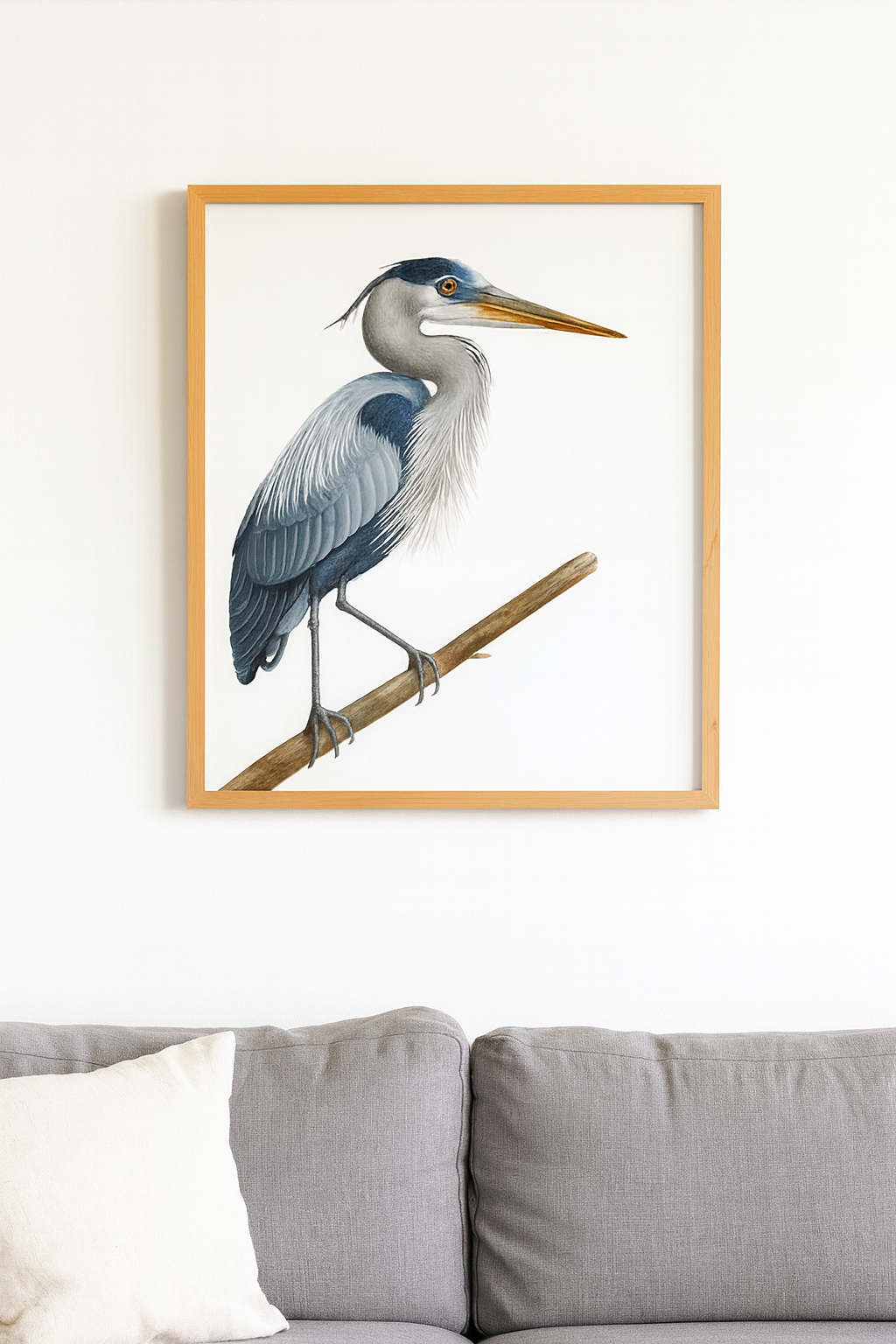 Framed artwork of a heron on a branch above a sofa